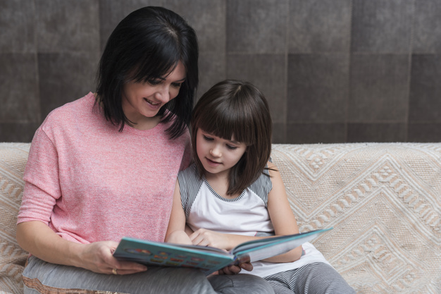 mother-little-daughter-reading-book-couch_23-2148070438